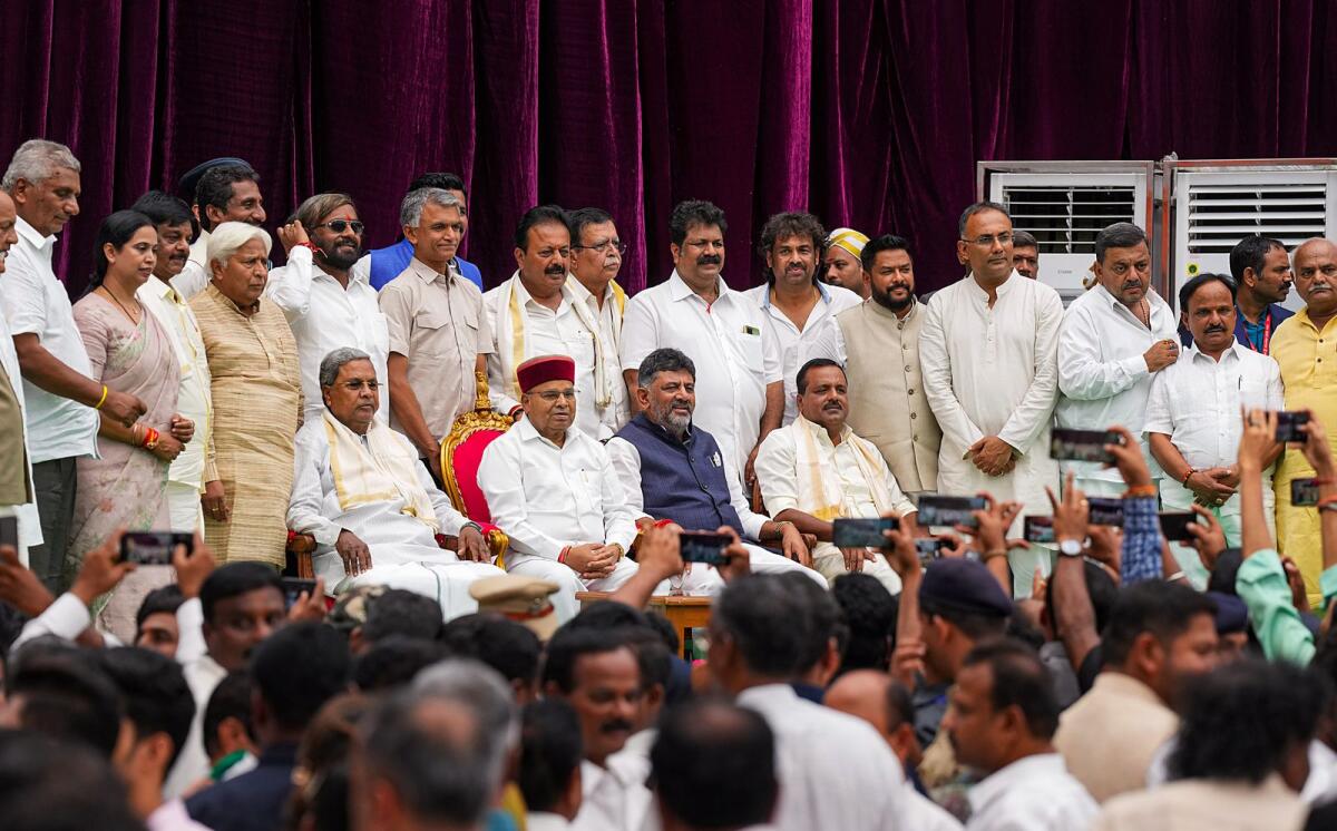 Karnataka Governor Thaawarchand Gehlot, Karnataka Chief Minister Siddaramaiah and Deputy Chief Minister DK Shivakumar with newly-inducted cabinet ministers during the swearing-in ceremony at Raj Bhavan in Bengaluru on Saturday. Photo: PTI