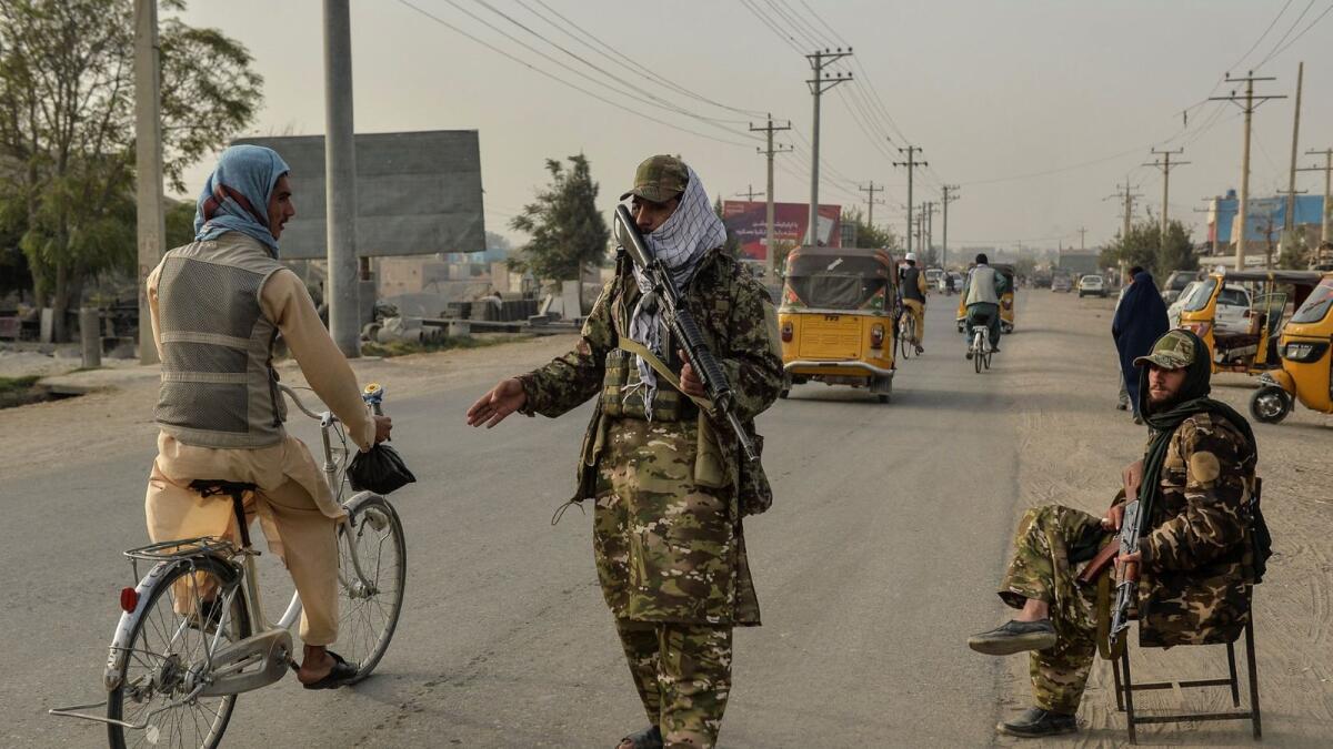 Taliban fighters check a resident along a road in Afghanistan. – AFP