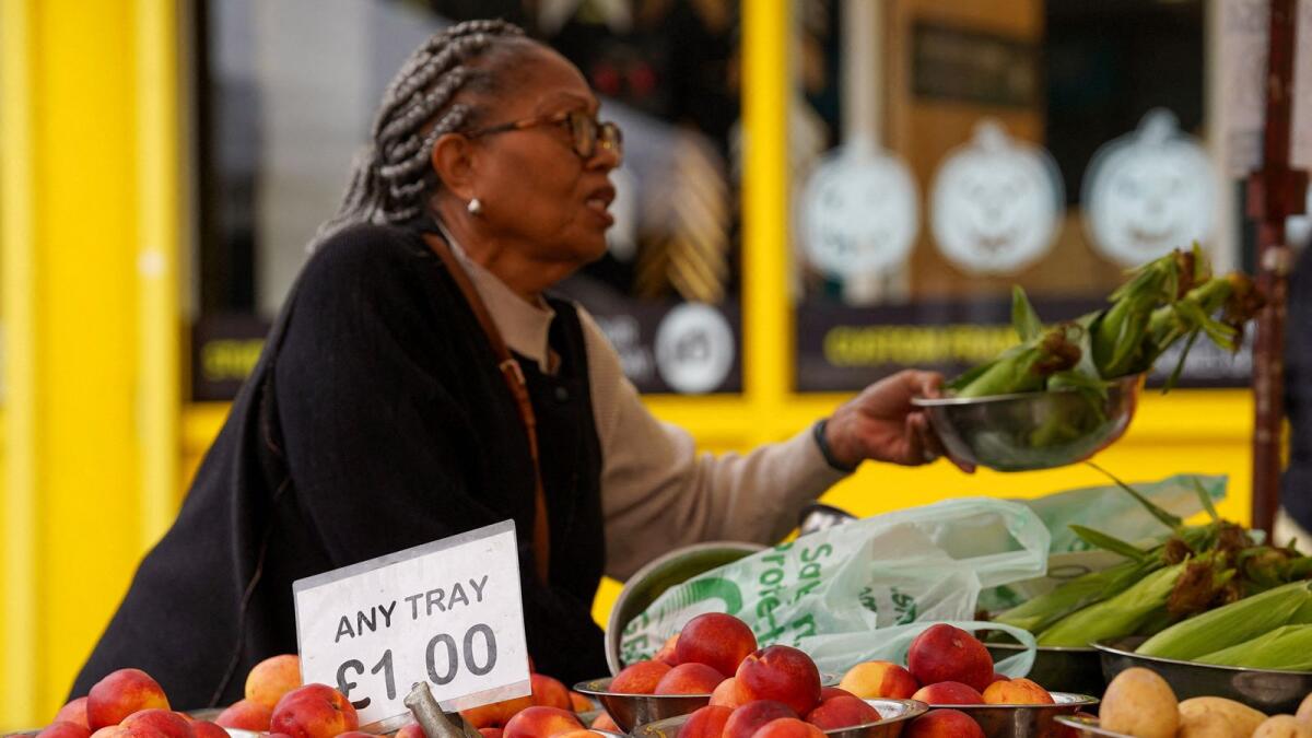 A woman shops for food items at a market stall in London. — Reuters file