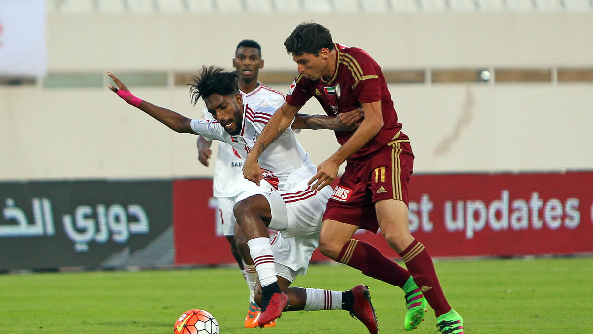 Al Wahda’ s Sebastian Tagliabue  and Abdulla Ghanem of Sharjah fight for the ball during their Arabian Gulf League game in Sharjah on Friday. — Photo by Juidin Bernarrd