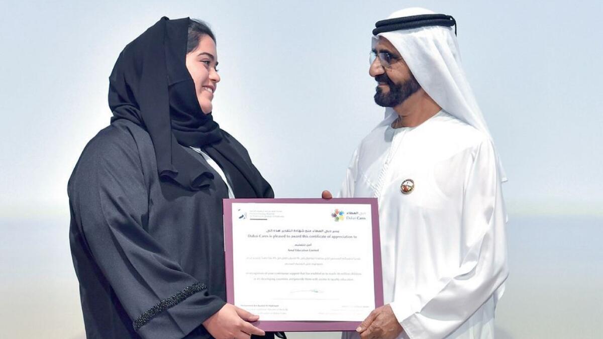 A representative of Amal Education Limited receives her certificate from Sheikh Mohammed for their support to Dubai Cares.