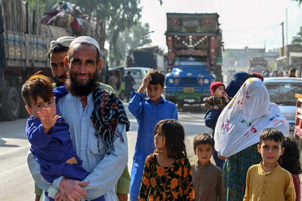 An Afghan refugee family living in Pakistan arrives outside the United Nations High Commissioner for Refugees (UNHCR) repatriation centre, some 25 Km from Peshawar on October 25, 2023. – AFP