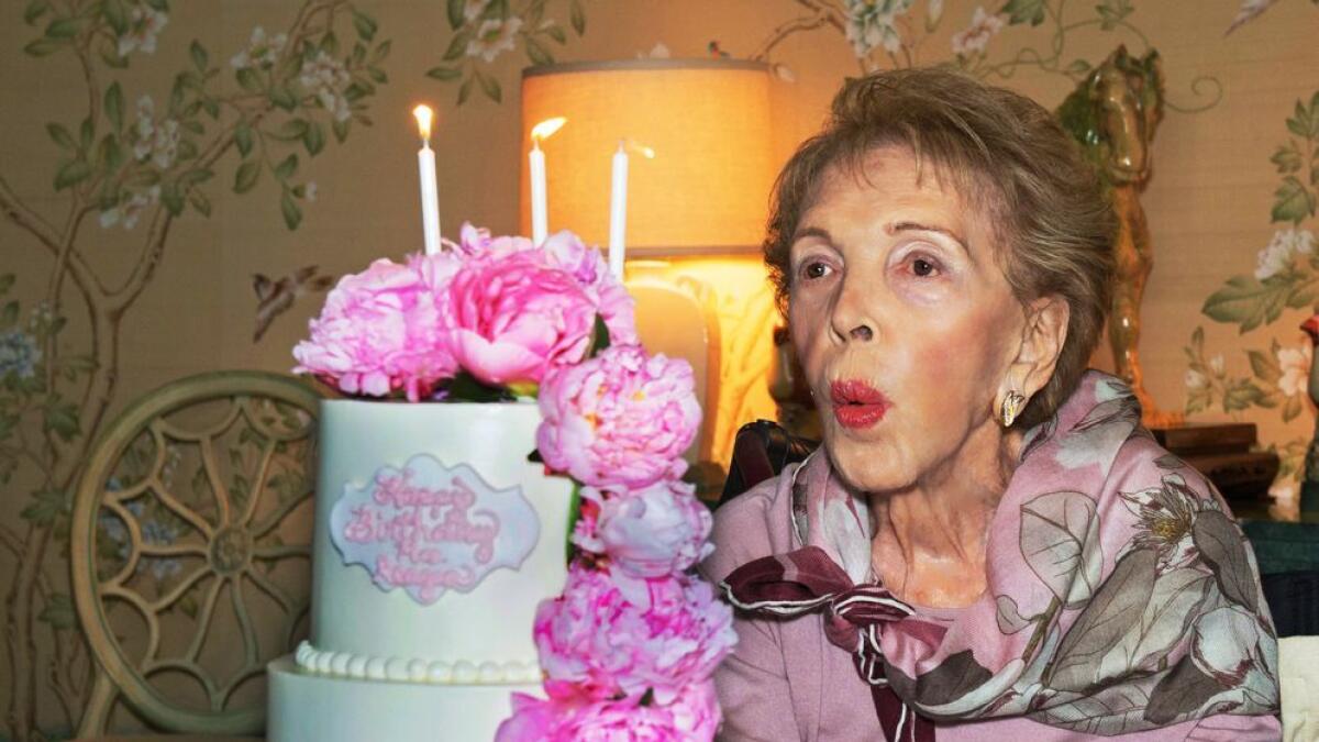 In this photo provided by the Ronald Reagan Presidential Foundation, Nancy Reagan blows out candles on a cake as she celebrates her 94th birthday at her home in the Bel-Air district of Los Angeles. -AP