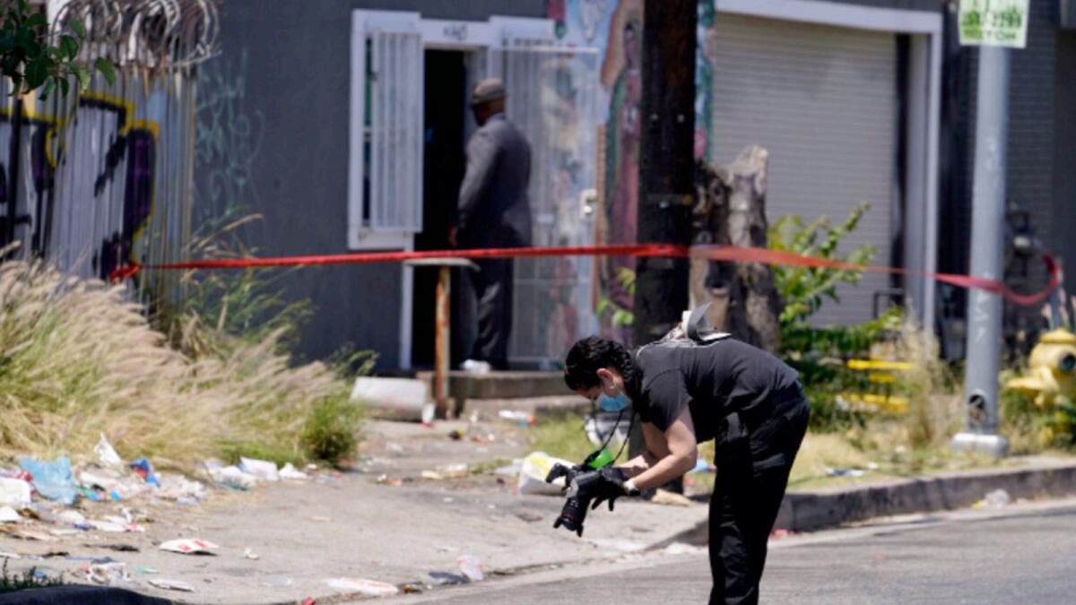 A Los Angeles Police field forensic photographer documents evidence after a shooting at a warehouse party. — AP