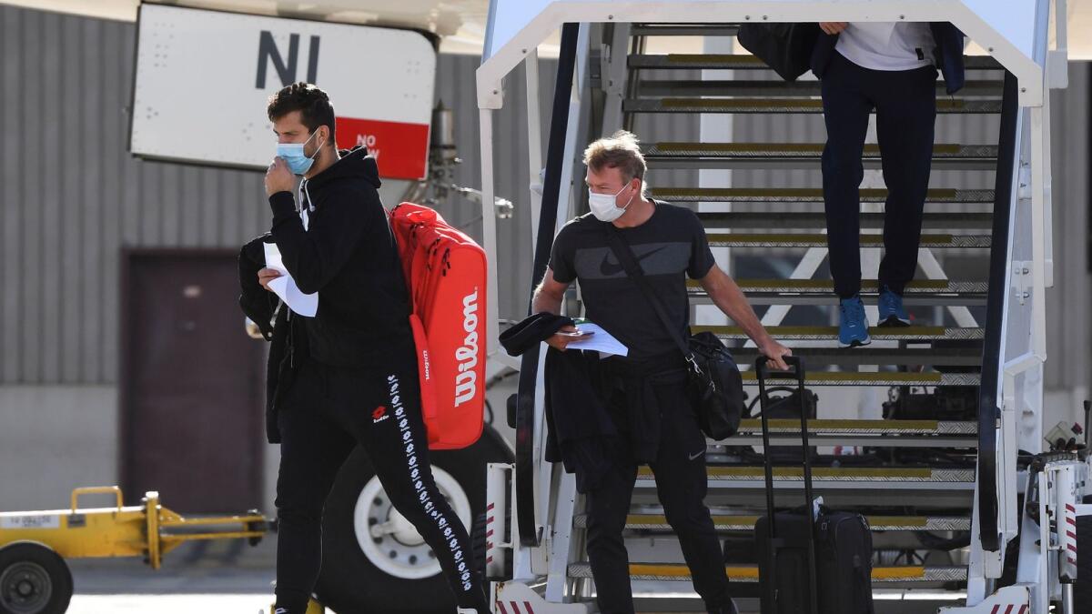 Tennis players and officials disembark from a flight after arriving in Melbourne. — AFP