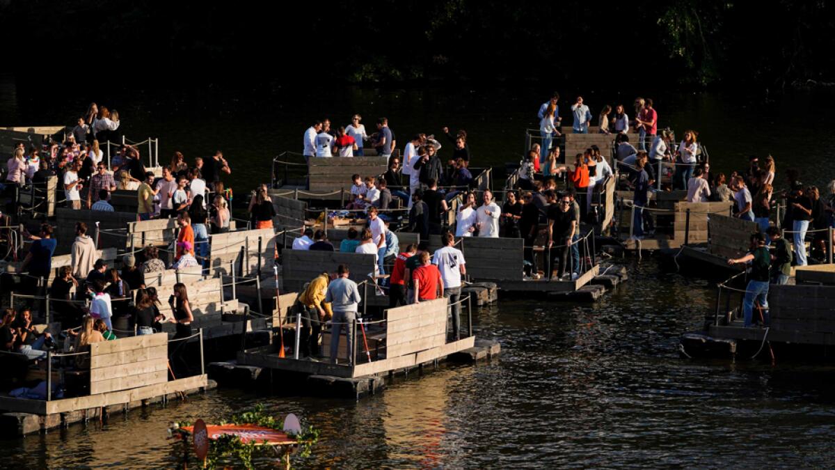Party-goers take part in a special edition of the 'Paradise City' festival, where people can enjoy the live performances from private boats, in Perk near Brussels. Photo: AFP