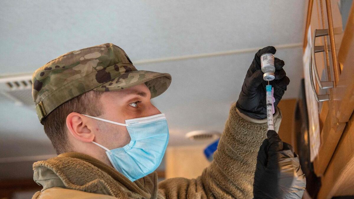 A soldier fills syringes with vaccine at a vaccination centre in Londonderry, New Hampshire.