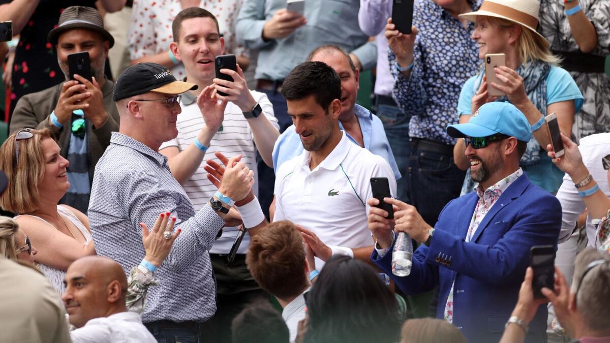 Serbia's Novak Djokovic returns to the court after celebrating with his team after defeating Italy's Matteo Berrettini in Wimbledon final. — AFP
