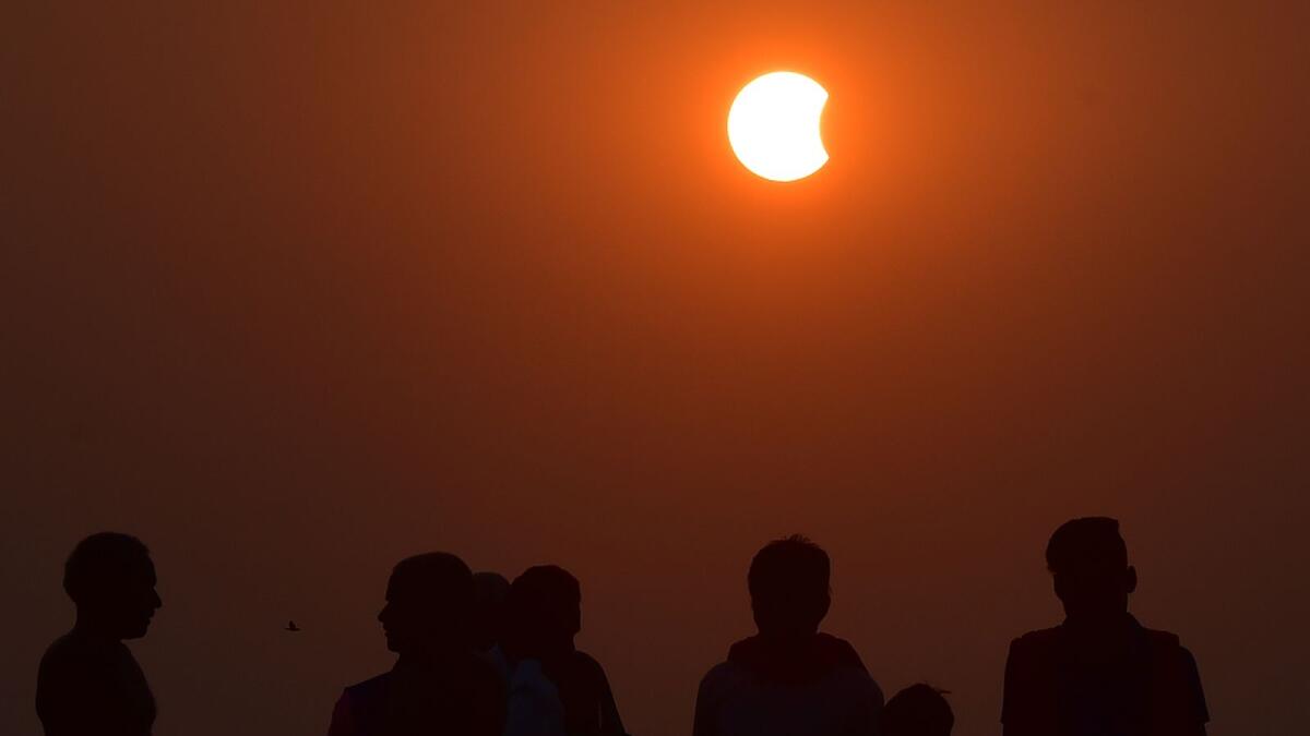 People watch the partial solar eclipse over Sangam, the confluence of the Rivers Ganges, Yamuna and mythical Saraswati, in Allahabad, India. (AFP)