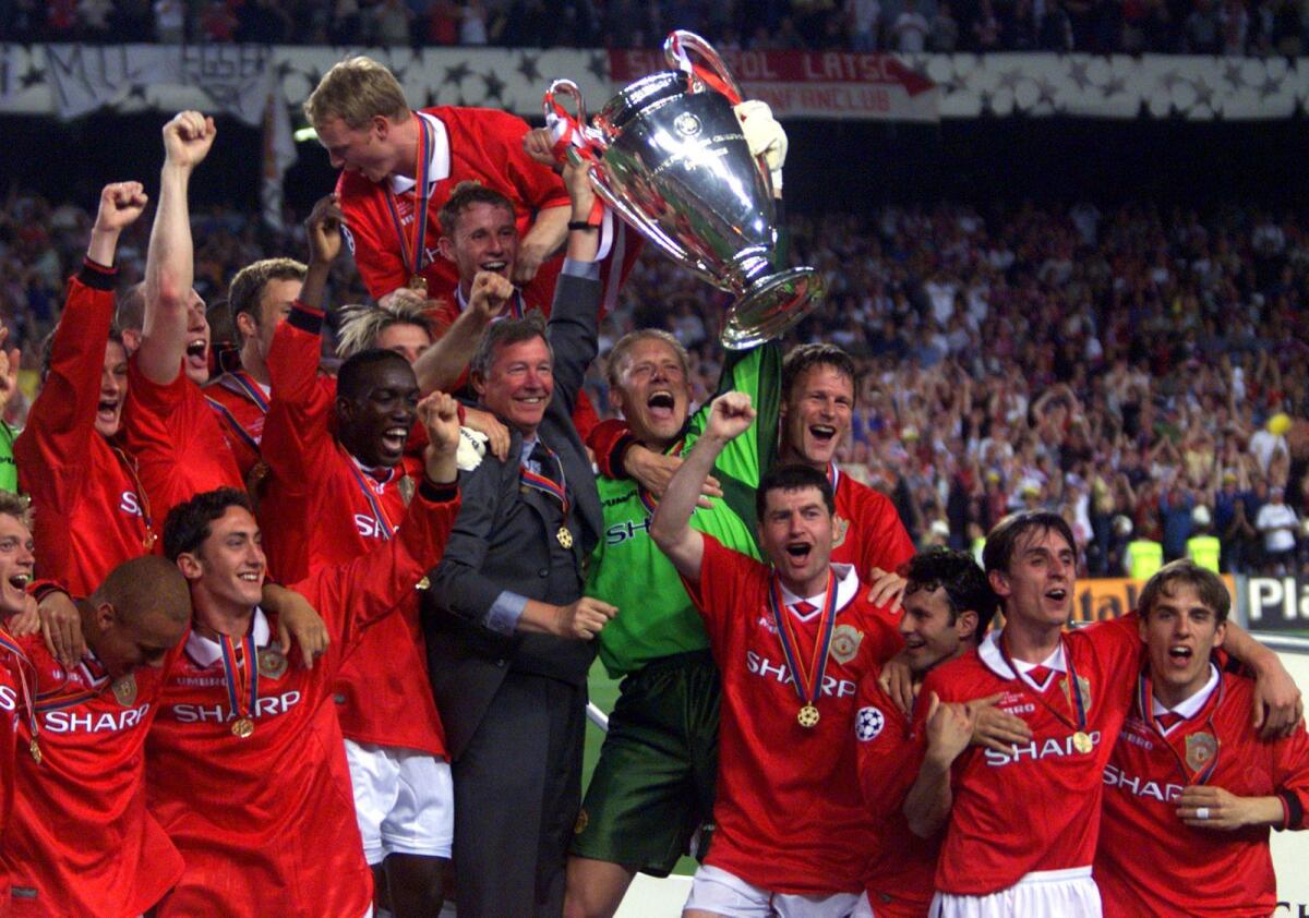 Manchester United players celebrate with the trophy after wining the 1999 Champions Cup final against Bayern Munich. — AP file