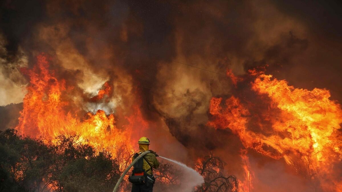 San Miguel County Firefighters battle a brush fire along Japatul Road during the Valley Fire in Jamul, California.