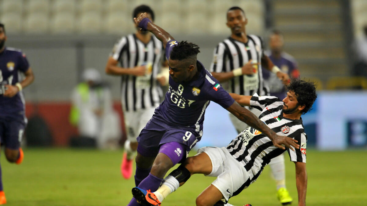 Al Ain’s Emmanuel Emenike (left) and Al Jazira’s Jacob Alhosani vie for ball possession at the Mohammed bin Zayed Stadium in Abu Dhabi on Friday. — Photos by Nezar Balout