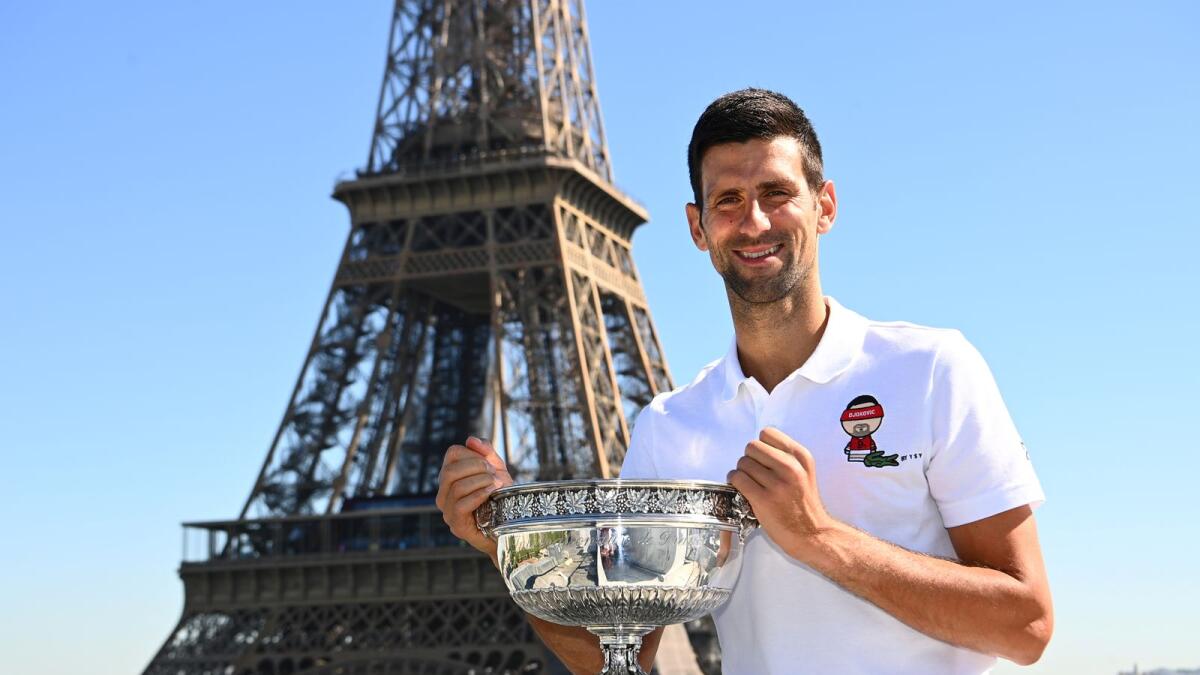 Serbia's Novak Djokovic poses in front of the Eiffel Tower with the trophy after winning the men's singles French Open title. — reuters