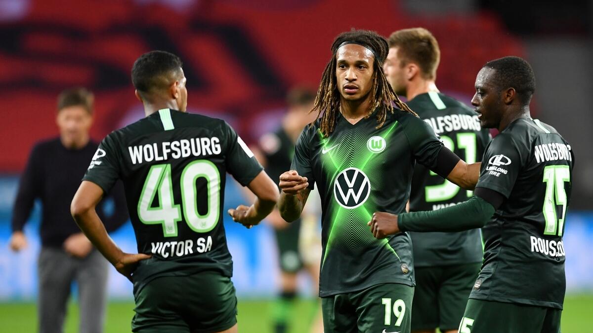 VfL Wolfsburg's Kevin Mbabu, Joao Victor and Jerome Roussillon celebrate after the match (Reuters)