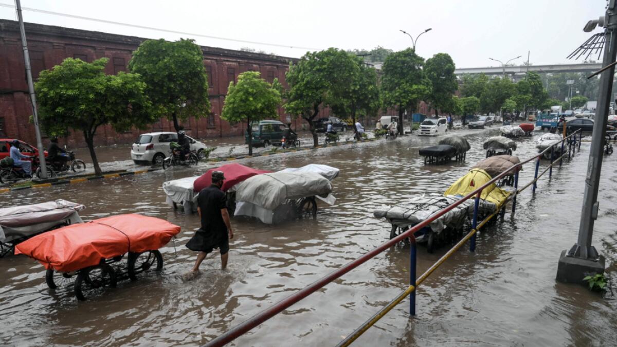 Street vendors pull their carts protected with tarpaulin as they wade through a flooded street after heavy monsoon rains in Lahore, Pakistan. Photo: AFP(Research: Mohammad Thanweeruddin)
