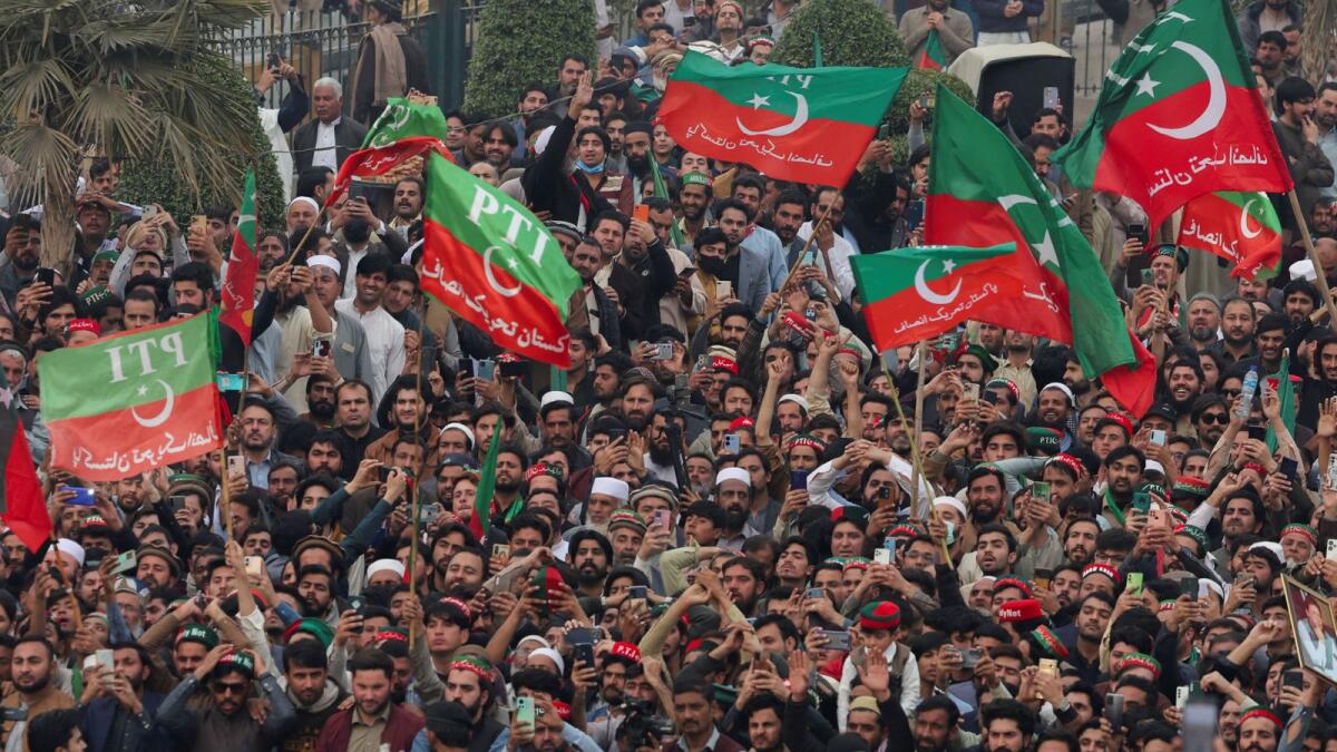 Supporters of Imran Khan wave flags as they protest demanding free and fair results of the elections in Peshawar. — Reuters