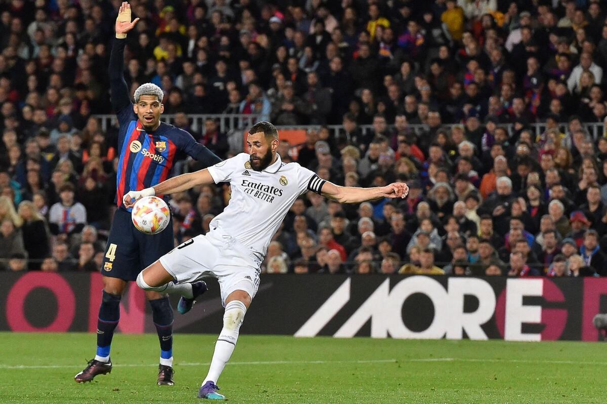 Real Madrid's Karim Benzema (right) scores his team's fourth goal against Barcelona. — AFP