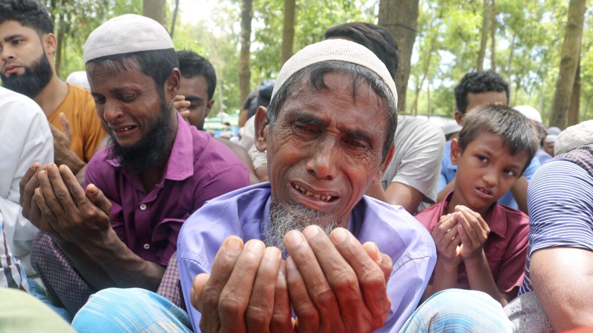 Rohingya refugees cry while praying during a gathering to mark the fifth anniversary of their exodus from Myanmar to Bangladesh at a Kutupalong Rohingya refugee camp on Thursday. — AP