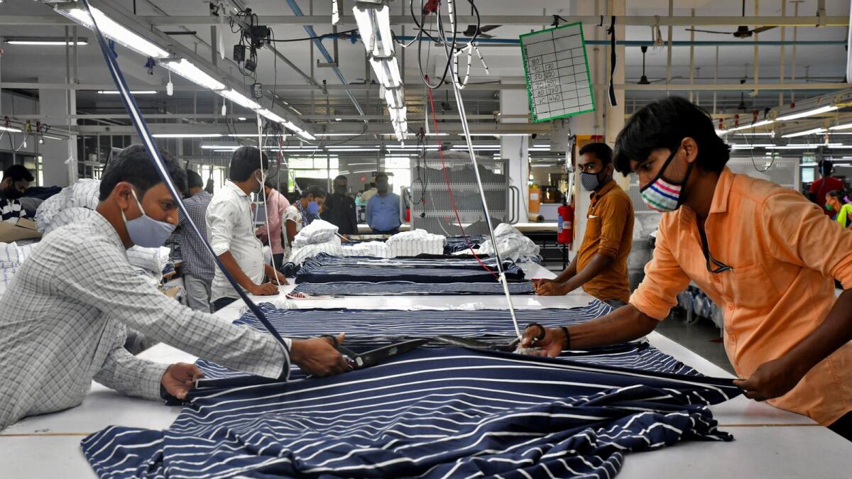 Garment workers cut fabric to make shirts at a textile factory in the southern Indian state of Andhra Pradesh. - Reuters