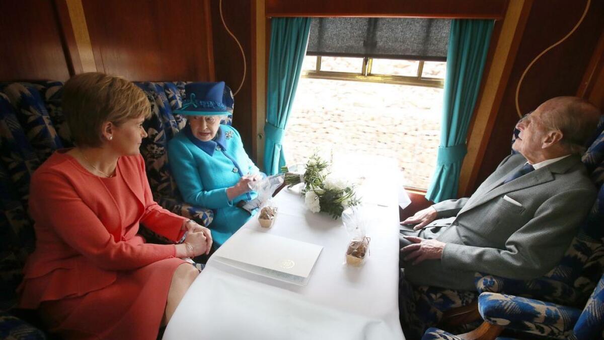 Britains Queen Elizabeth II, and Prince Philip, sit with Scotlands First Secretary Nicola Sturgeon, left as they travel on a steam train en-route to Edinburgh in Scotland.