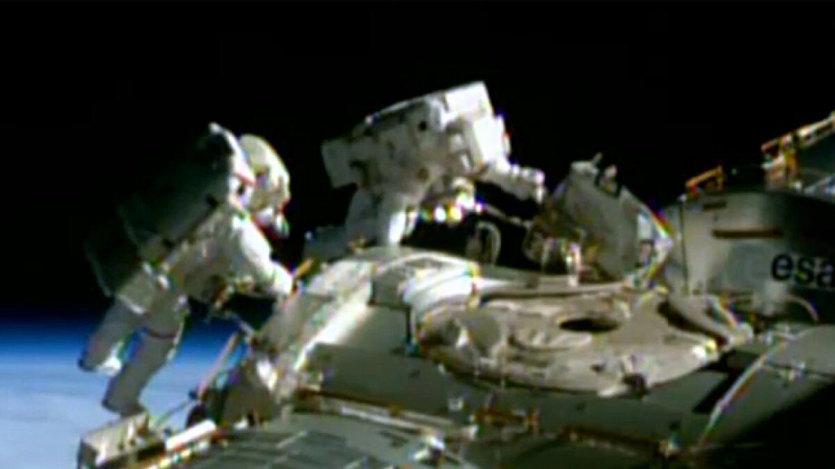 Spacewalking astronauts rig station for new US space taxis