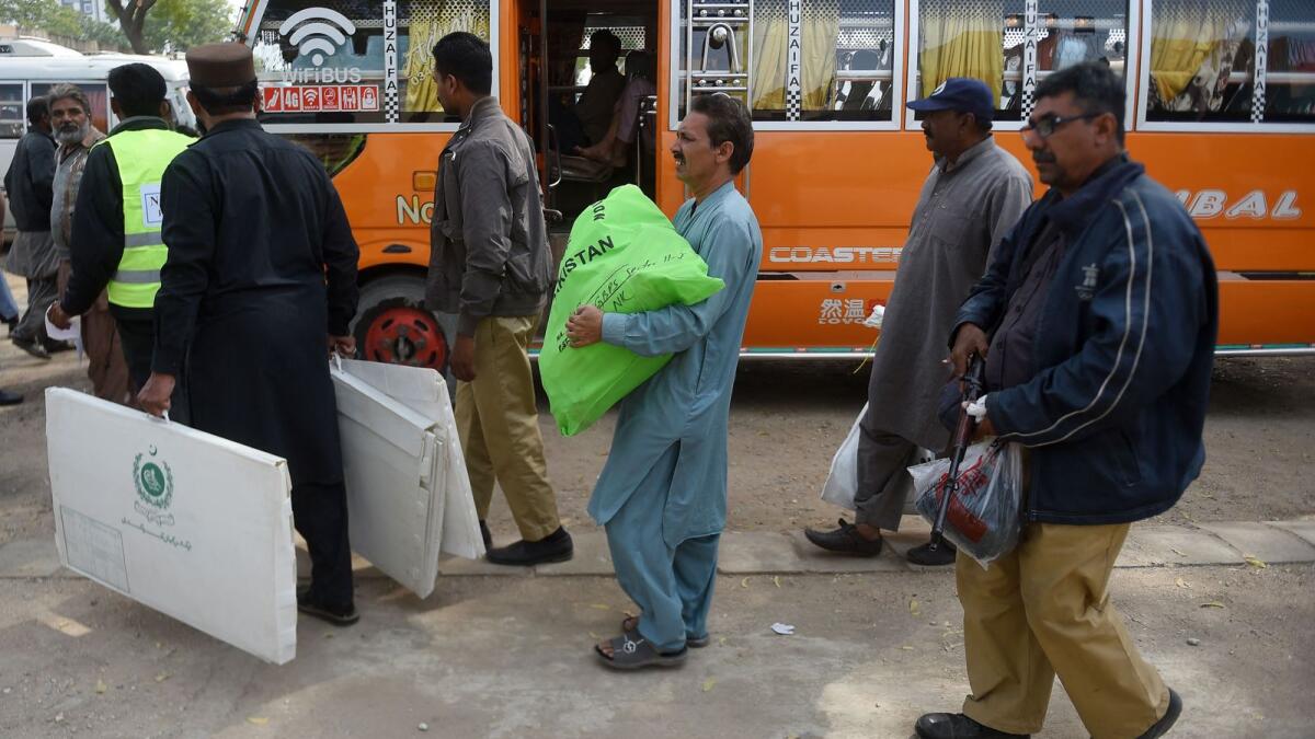 Election presiding officers leave after collecting voting materials at a distribution centre in Karachi on Wednesday. Photo: AFP