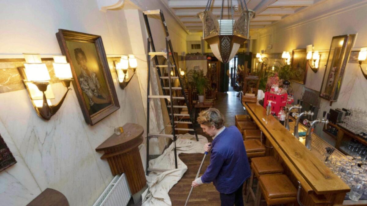 A bar staff member cleans the floor before its opening after the Covid-19 lockdown in Amsterdam. — AFP
