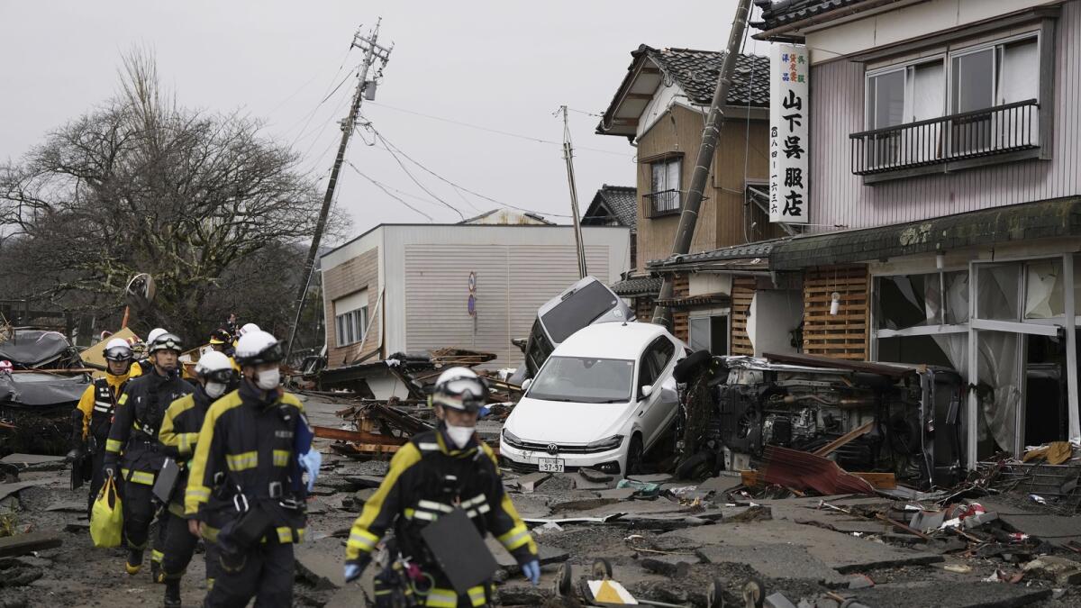 Firefighters search the earthquake-hit area in Suzu. — AP