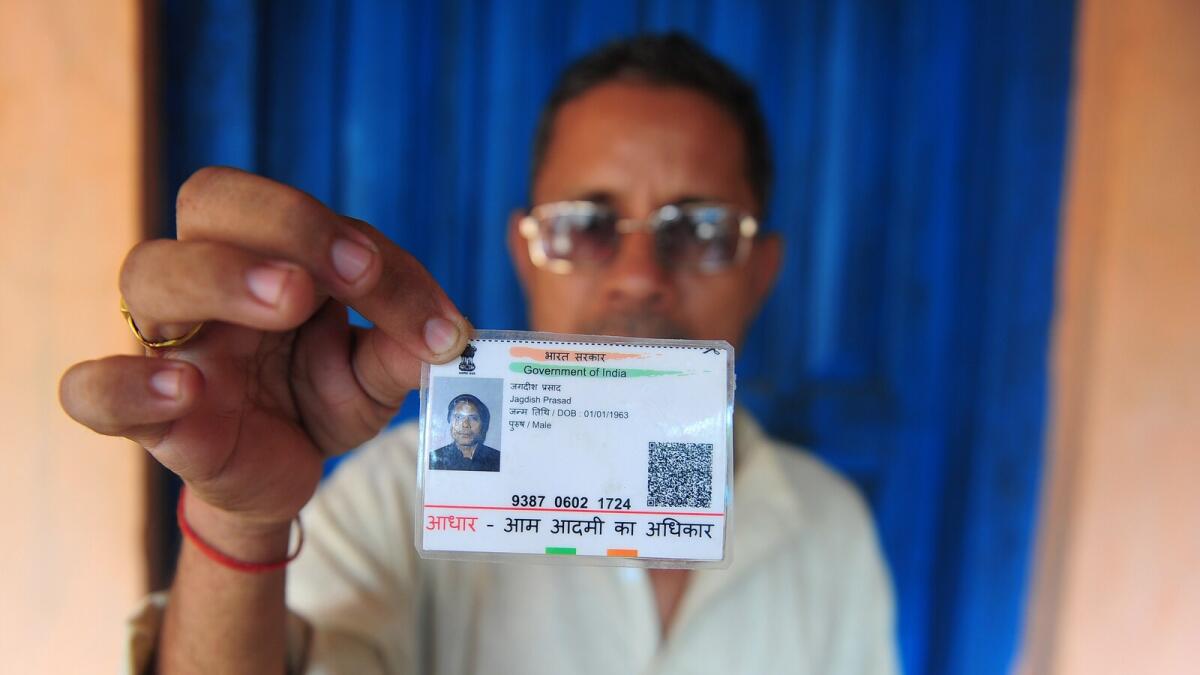 Jagdish Prasad Gupta poses for a photograph with his identity card in Mau district. Gupta is battling to prove that he has ever existed.