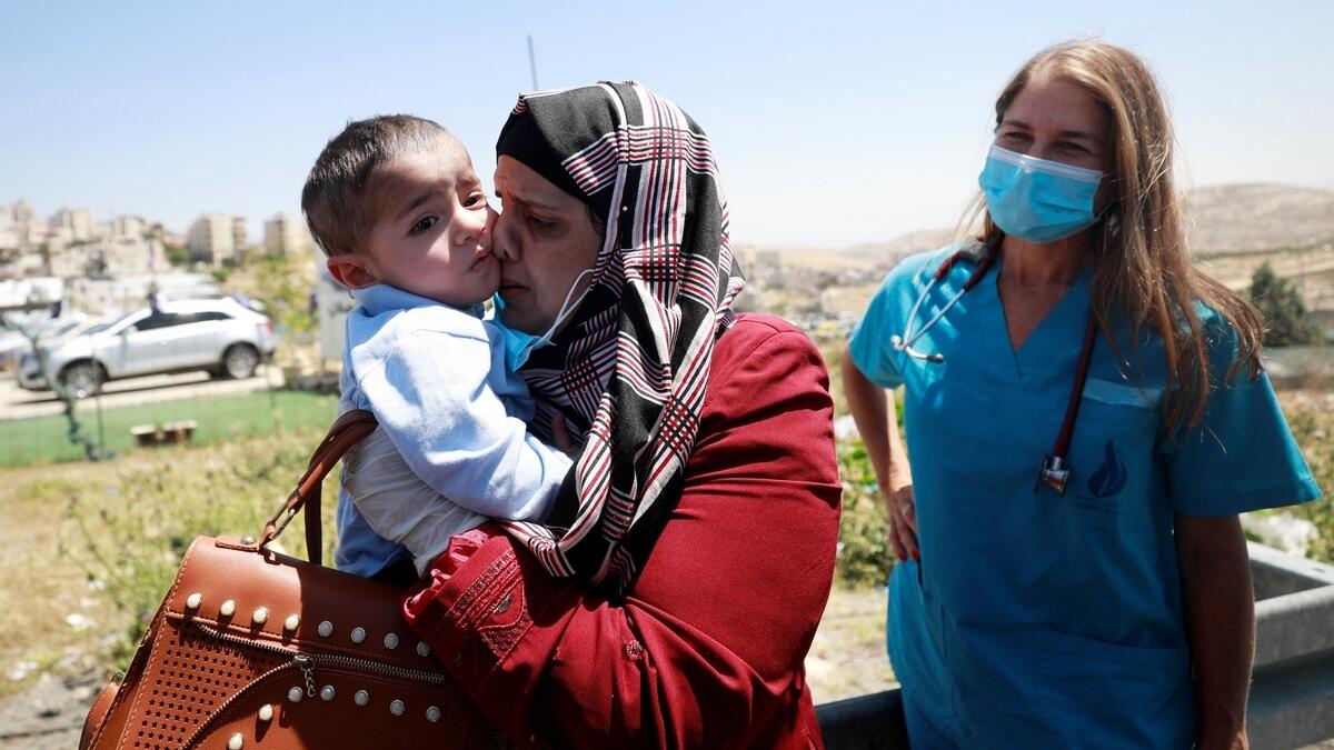 Palestinian boy Hamza Ali Mohammed, 2, who was treated for a congenital heart disease in a hospital in Israel and separated from his family for two months due to the coronavirus disease (Covid-19) lockdown, is carried by his mother upon his arrival at a checkpoint near Ramallah in the Israeli-occupied West Bank May 7, 2020.