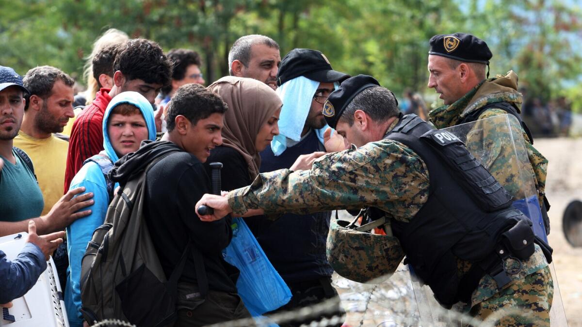 Migrants try to pass through border police near to the town of Idomeni, on the Greece-Macedonia border on Saturday. — AFP. Hundreds of mostly Syrian refugees forced their way over the Macedonian border on August 22 as police hurled stun grenades in a failed bid to stop them breaking through, an AFP reporter said.  Police subsequently seemed to regain control of the situation, stopping the flow of people after hurling a dozen stun grenades in some 30 minutes. Some 1,500 migrants and refugees — AFP