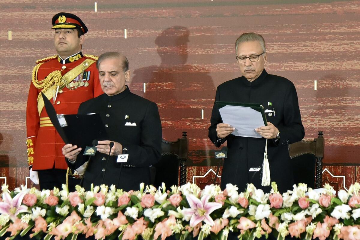Pakistan President Arif Alvi (R) administers the oath of office to Shehbaz Sharif in Islamabad. Photo: AP