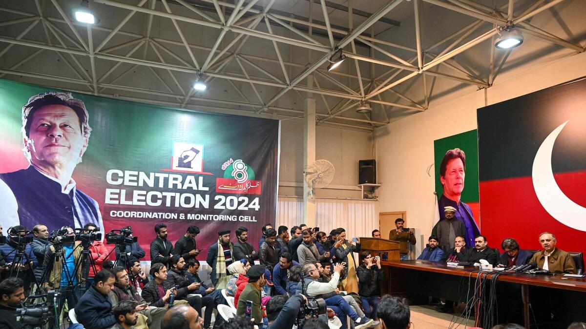 Imran Khan's Pakistan Tehreek-e-Insaf (PTI) party nominee for prime minister, Omar Ayub Khan (R), speaks during a press conference at PTI's central secretariat in Islamabad. — AFP