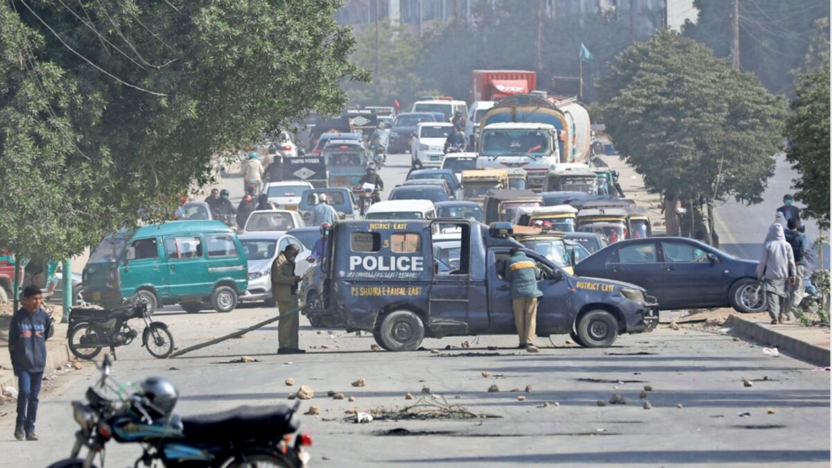 A police vehicle is parked on a road covered with stones thrown by protesters in Karachi following the killings of coal miners in an attack in the Mach area of Bolan district. — Reuters