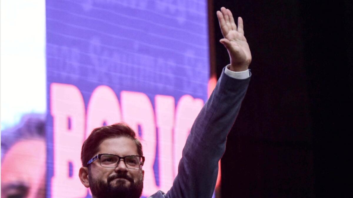 Gabriel Boric waves to supporters during his closing campaign rally in Santiago. — AFP