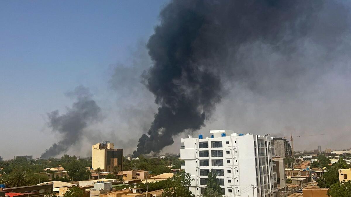 Smoke billows above residential buildings in Khartoum on Sunday. — AFO
