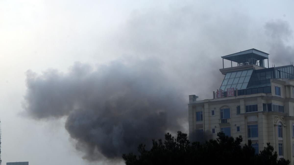 Smoke rises from a hotel building after an explosions and gunfire in the city of Kabul, Afghanistan, on Monday. — AP