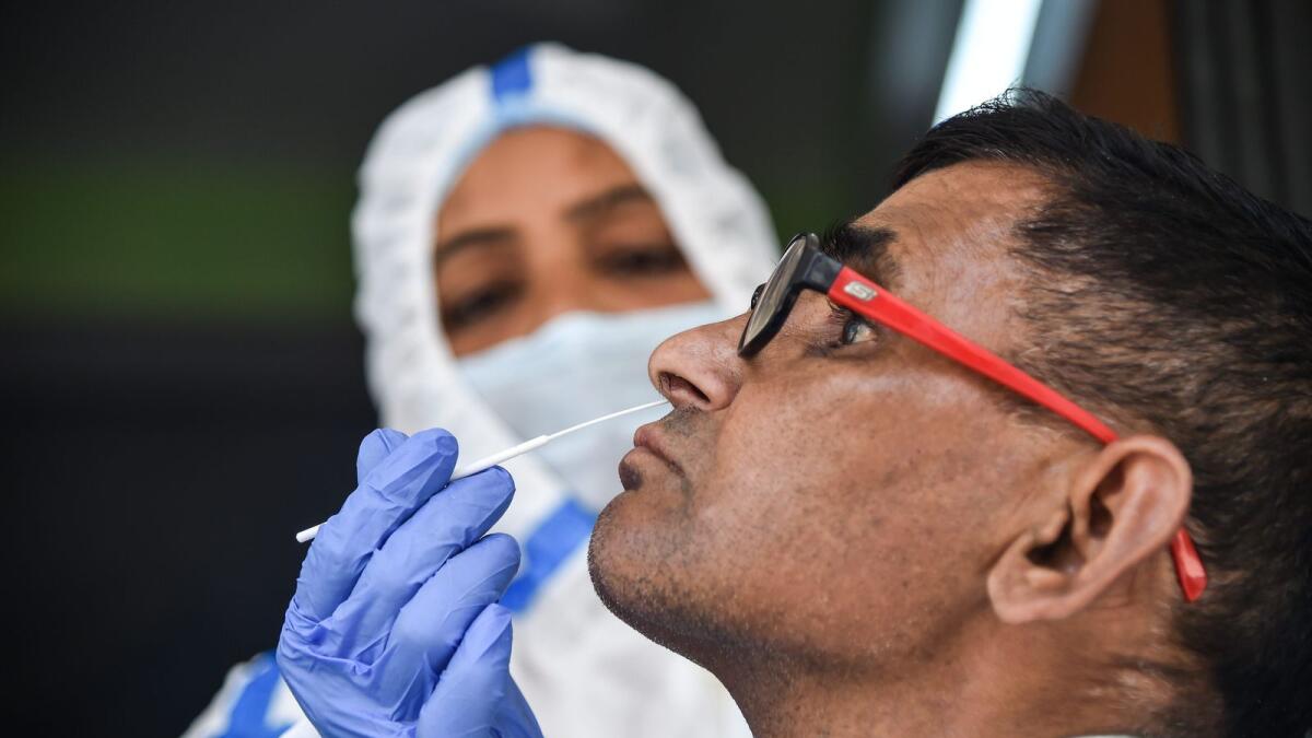A healthcare worker collects a swab sample of a man for Covid-19 test, amid a rise in coronavirus cases in India. — PTI