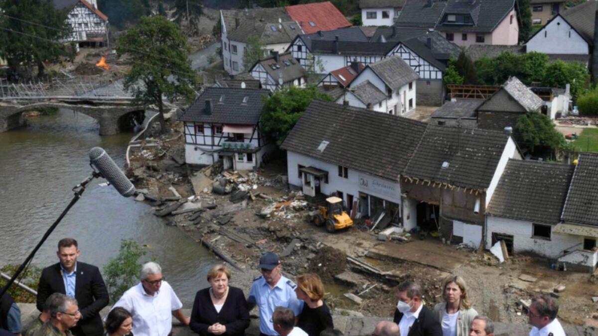German Chancellor Angela Merkel and Rhineland-Palatinate State Premier Malu Dreyer speak to people as they stand on a bridge during their visit in the flood-ravaged areas, in Schuld. — AFP