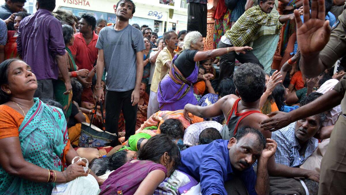 Indian devotees gather near the bodies of those killed after a stampede at a religious festival in Godavari in the Rajahmundry district some 200 kms north-east of Hyderabad on July 14, 2015.