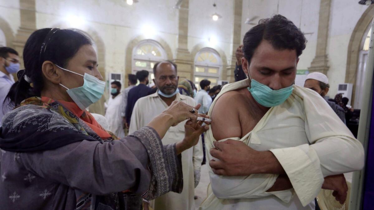 A man receives a shot of the Sinovac vaccine from a health worker, at a vaccination centre in Karachi. — AP