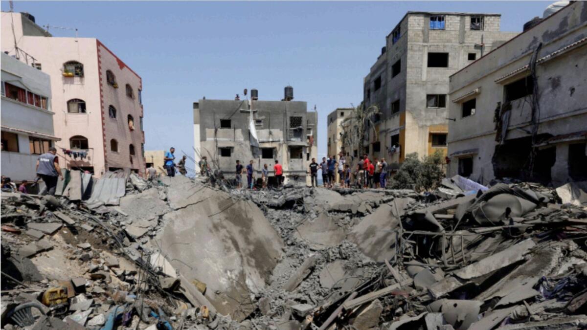 Palestinians inspect a house hit in an Israeli air strike in Gaza City. — Reuters