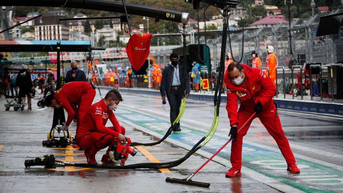 Ferrari crew clear rainwater off the pit lane at the Russian GP. (Reuters)