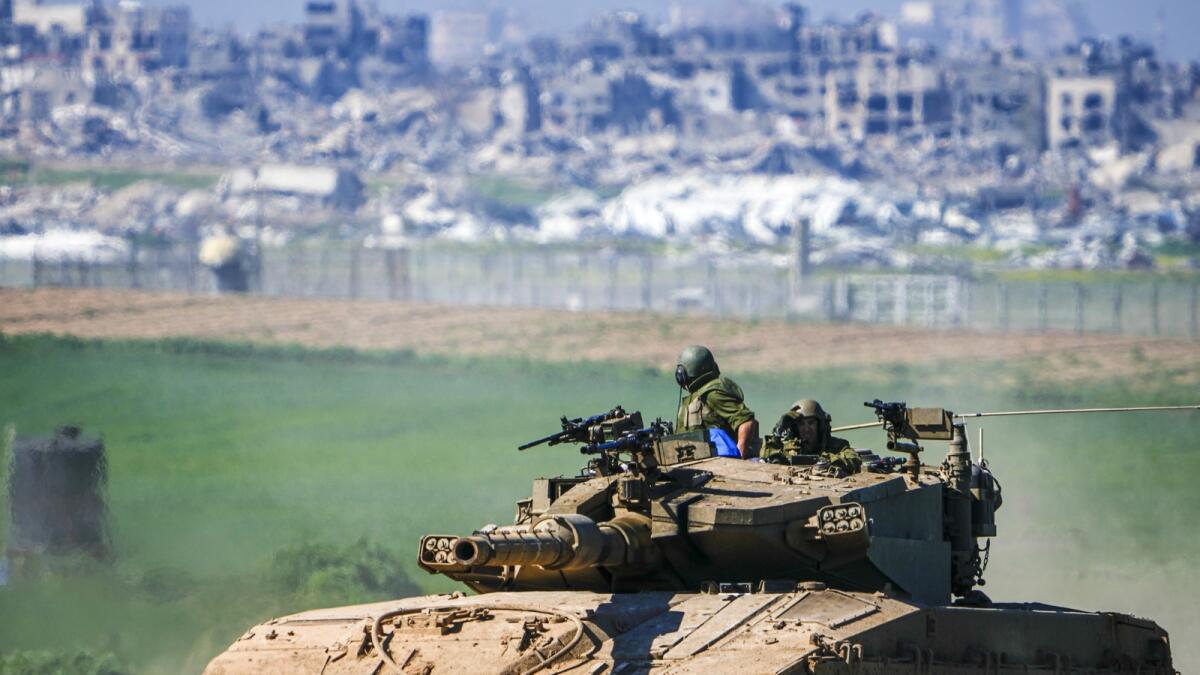 Israeli soldiers drive a tank on the border with the Gaza Strip, as seen in southern Israel. — AP