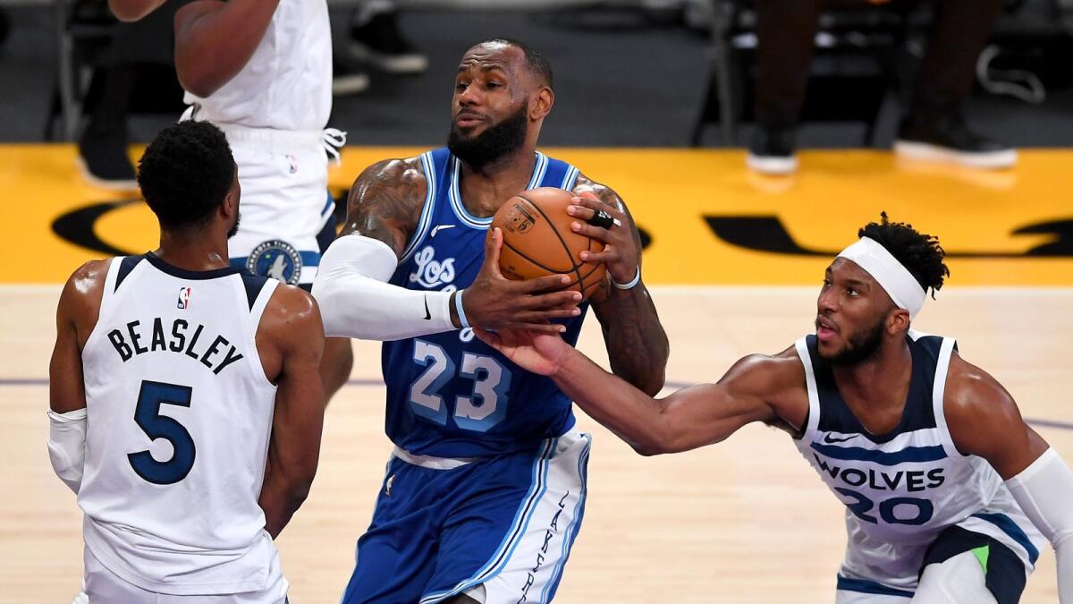 Minnesota Timberwolves guard Malik Beasley (5) and guard Josh Okogie (20) defend Los Angeles Lakers forward LeBron James (23) as he drives to the basket. — Reuters