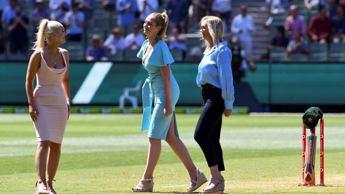 Augusta (left), Phoebe (centre) and Jane Jones (right), the wife and daughters of former Australian cricketer Dean Jones who died recently, place his baggy green hat and bat against the stumps during the tea break on the first day of the second Test in Melbourne. — AFP