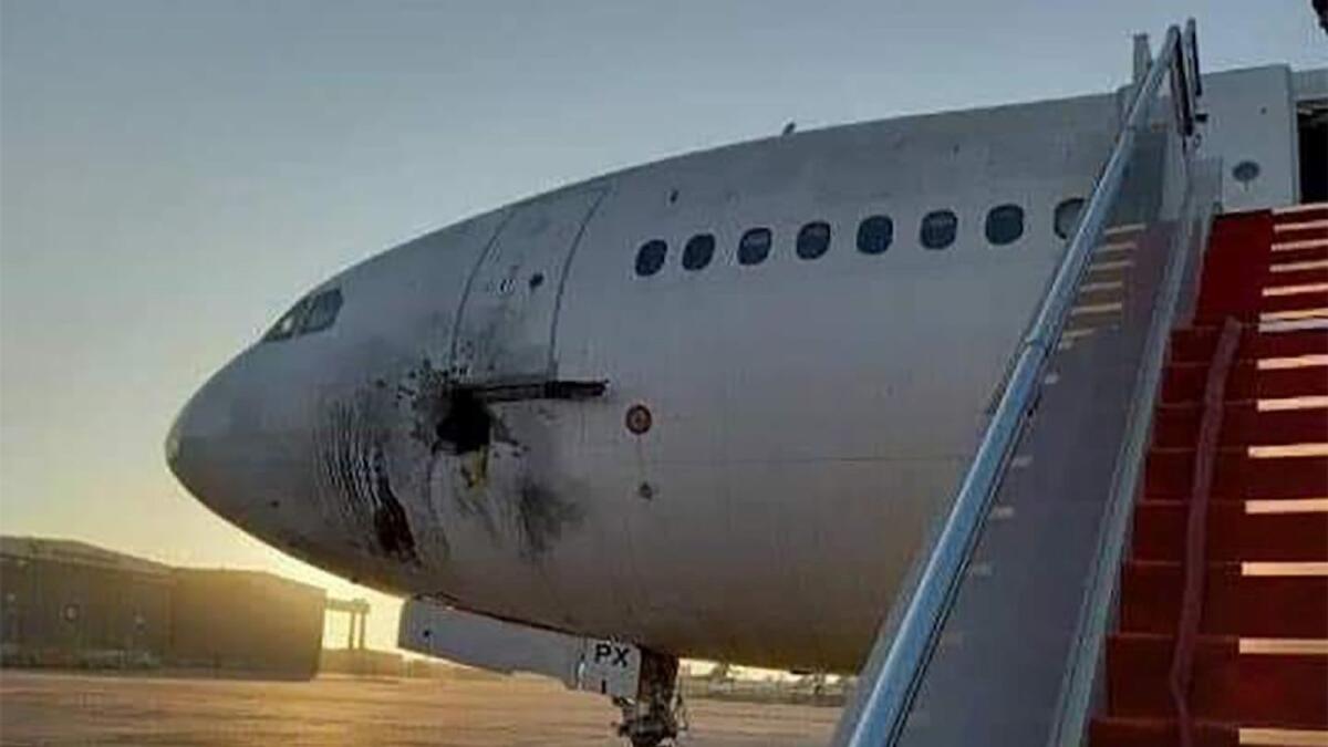 A damaged stationary aircraft on the tarmac of Baghdad airport, after rockets reportedly tragetted the runway. – AFP