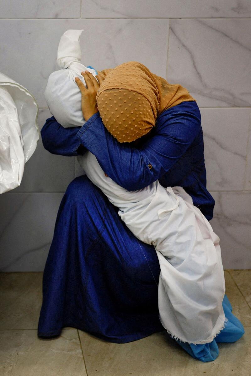 Palestinian woman Inas Abu Maamar, 36, embraces the body of her 5-year-old niece Saly, who was killed in an Israeli strike, at Nasser hospital in Khan Younis in the southern Gaza Strip, October 17, 2023. — Reuters