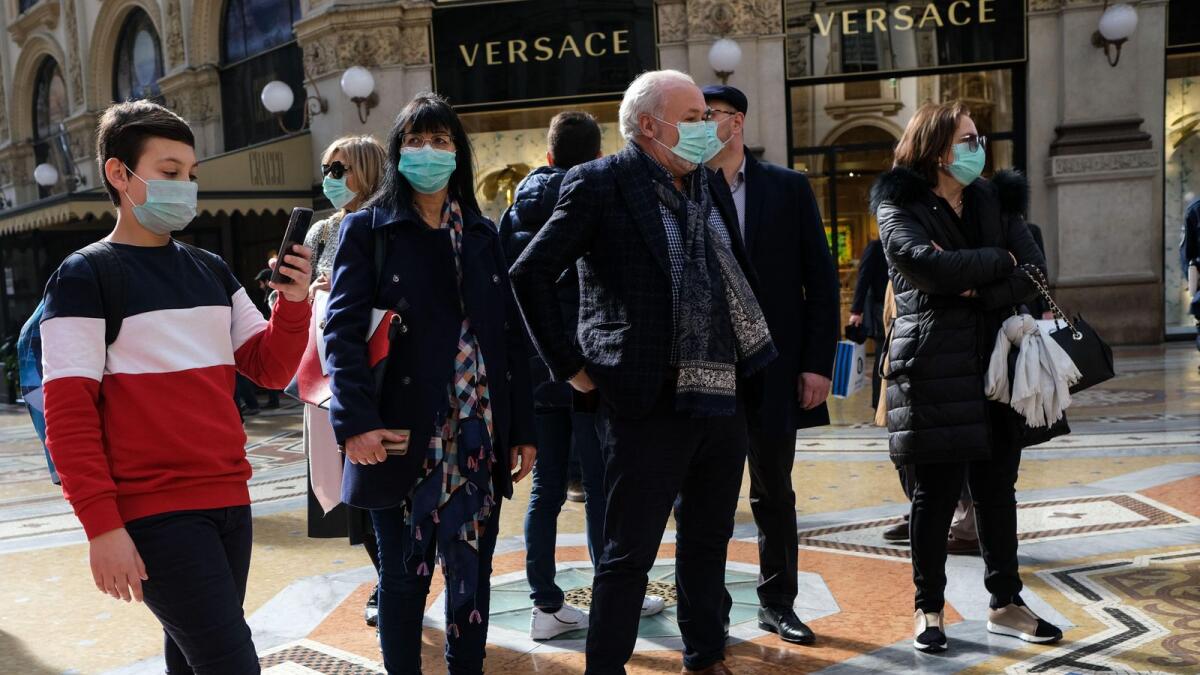 People in face masks to protect themselves from the coronavirus epidemic on the streets of Milan, Italy, in February 2020.