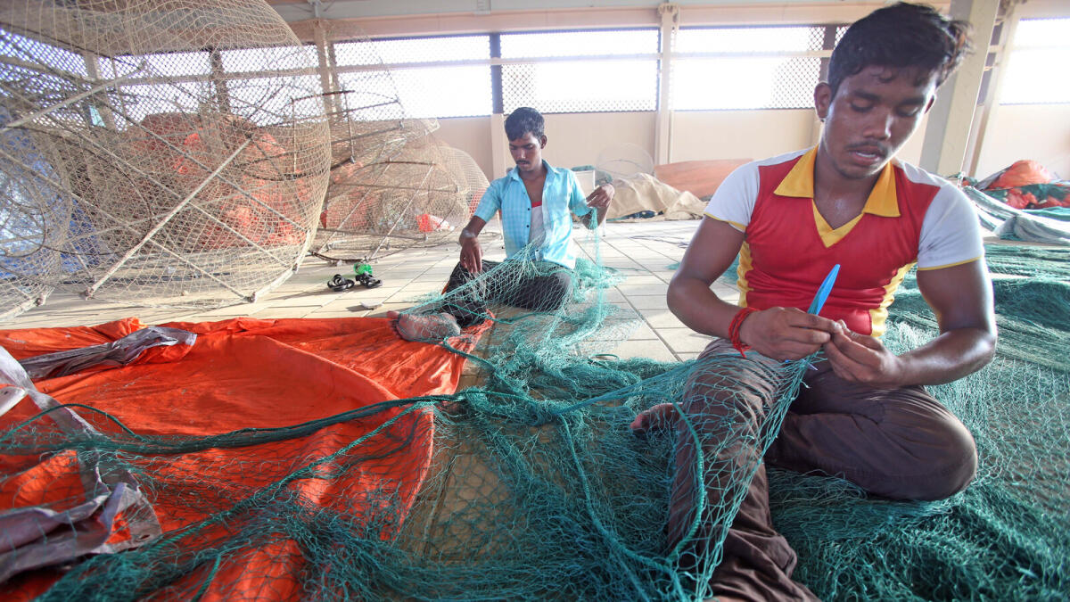 Fishermen weaving a fish net at the fish market in Umm Suqeim in Dubai.- Photo by Dhes Handumon/Khaleej Times